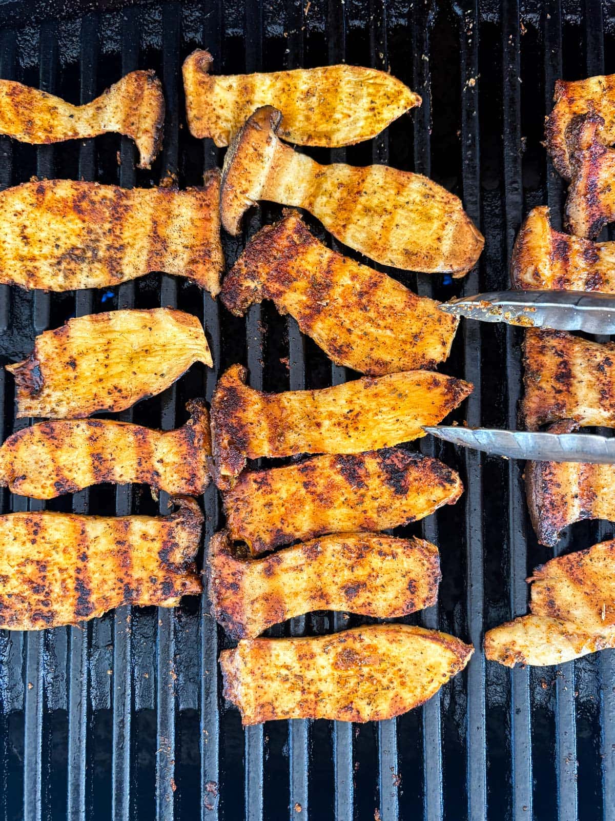 sliced king oyster mushrooms on the grill with souvlaki marinade.