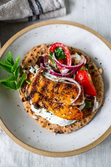 These Greek souvlaki pitas are filled with grilled king oyster mushrooms, a fresh tomato-feta salad, and creamy tzatziki for a quick, easy, 30-minute vegetarian Mediterranean meal.