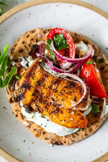 These Greek souvlaki pitas are filled with grilled king oyster mushrooms, a fresh tomato-feta salad, and creamy tzatziki for a quick, easy, 30-minute vegetarian Mediterranean meal.