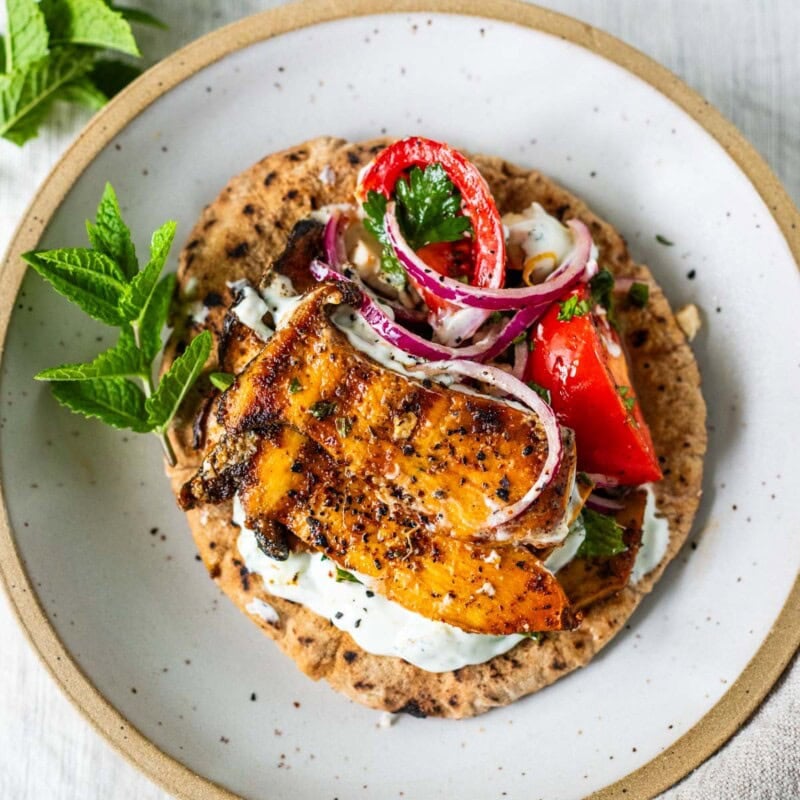 These Greek souvlaki pitas are filled with grilled king oyster mushrooms, a fresh tomato-feta salad, and creamy tzatziki for a quick, easy, 30-minute vegetarian Mediterranean meal.