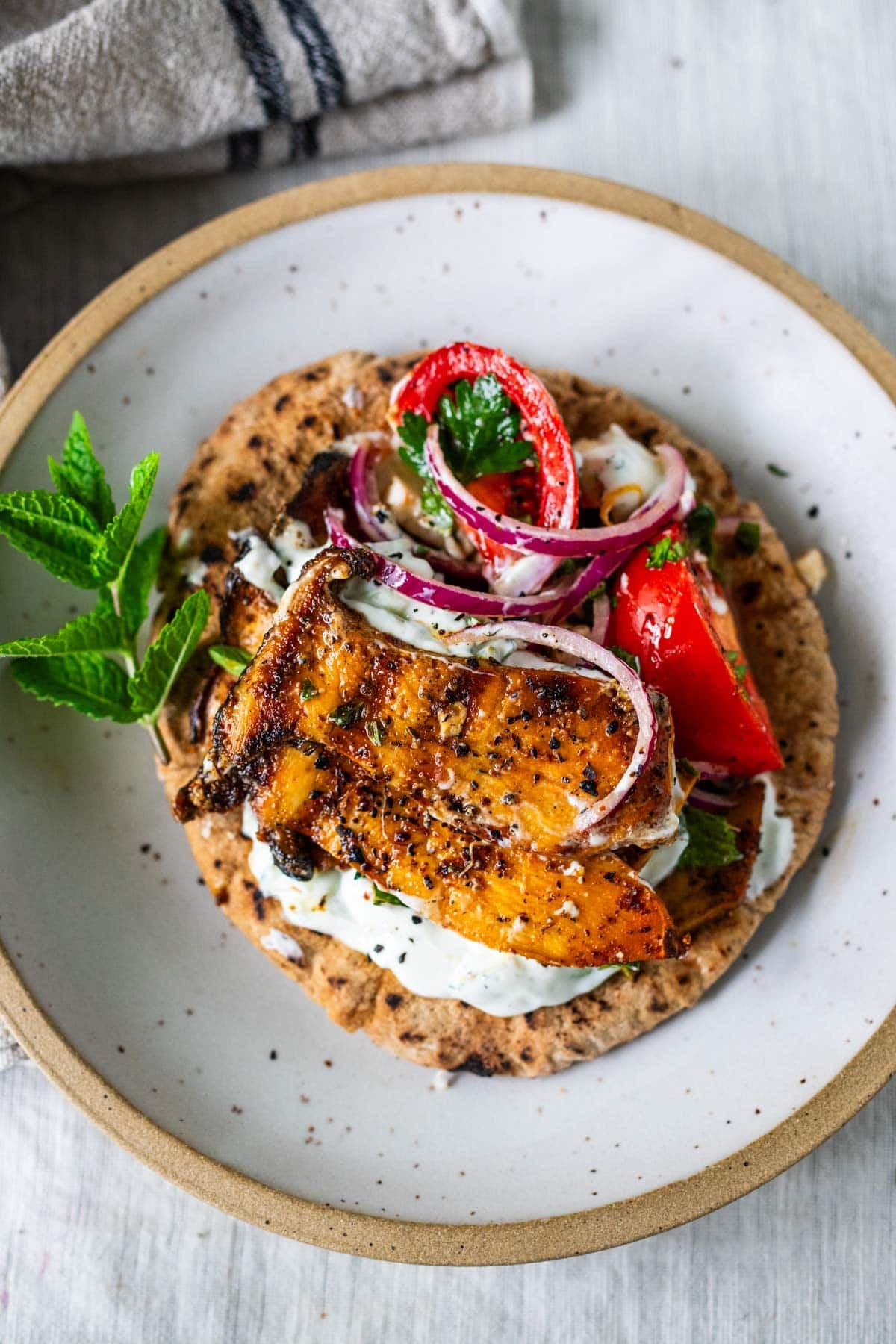 Greek souvlaki pita with king oyster mushroom, tomato onion salad with parsley, and tzatziki on pita.