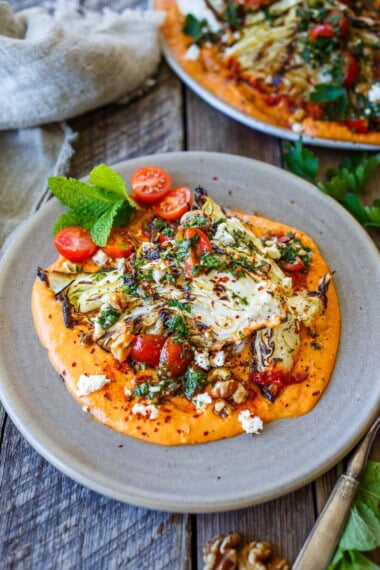 This Grilled Cabbage recipe turns humble cabbage into an elegant vegetarian meal or a hearty side dish with smoky char, tender leaves, creamy harissa white bean purée, and fresh tomato-herb gremolata. Perfect for summer entertaining! Gluten-free, vegan-adaptable.