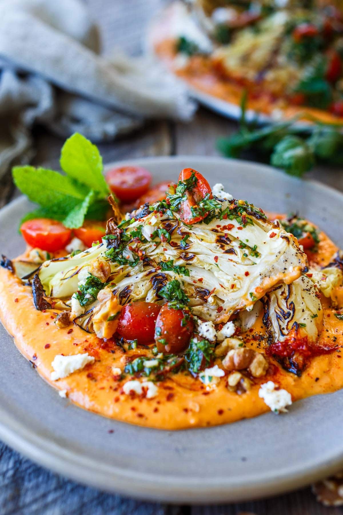 grilled cabbage wedge on harissa white bean puree, topped with tomato gremolata and feta.