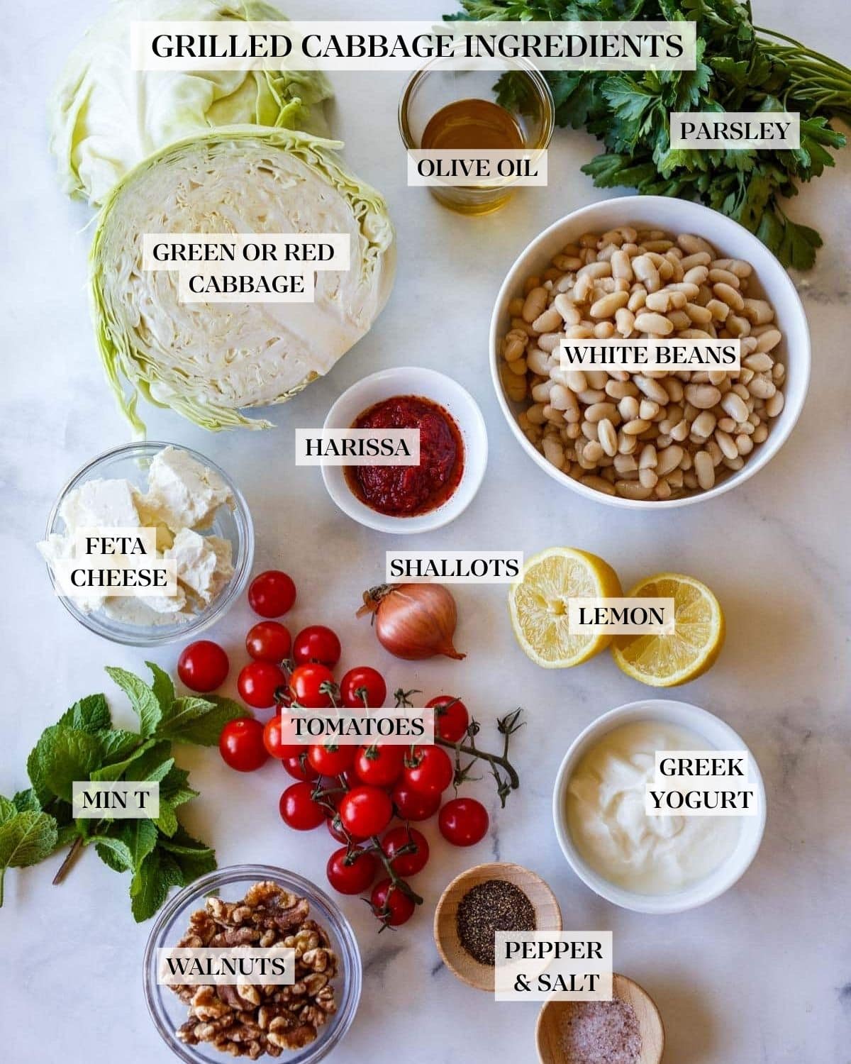 ingredients for grilled cabbage - parsley, olive oil, cabbage, white beans, harissa, feta, shallot, lemon, cherry tomatoes, Greek yogurt, mint, walnuts, pepper, and salt.