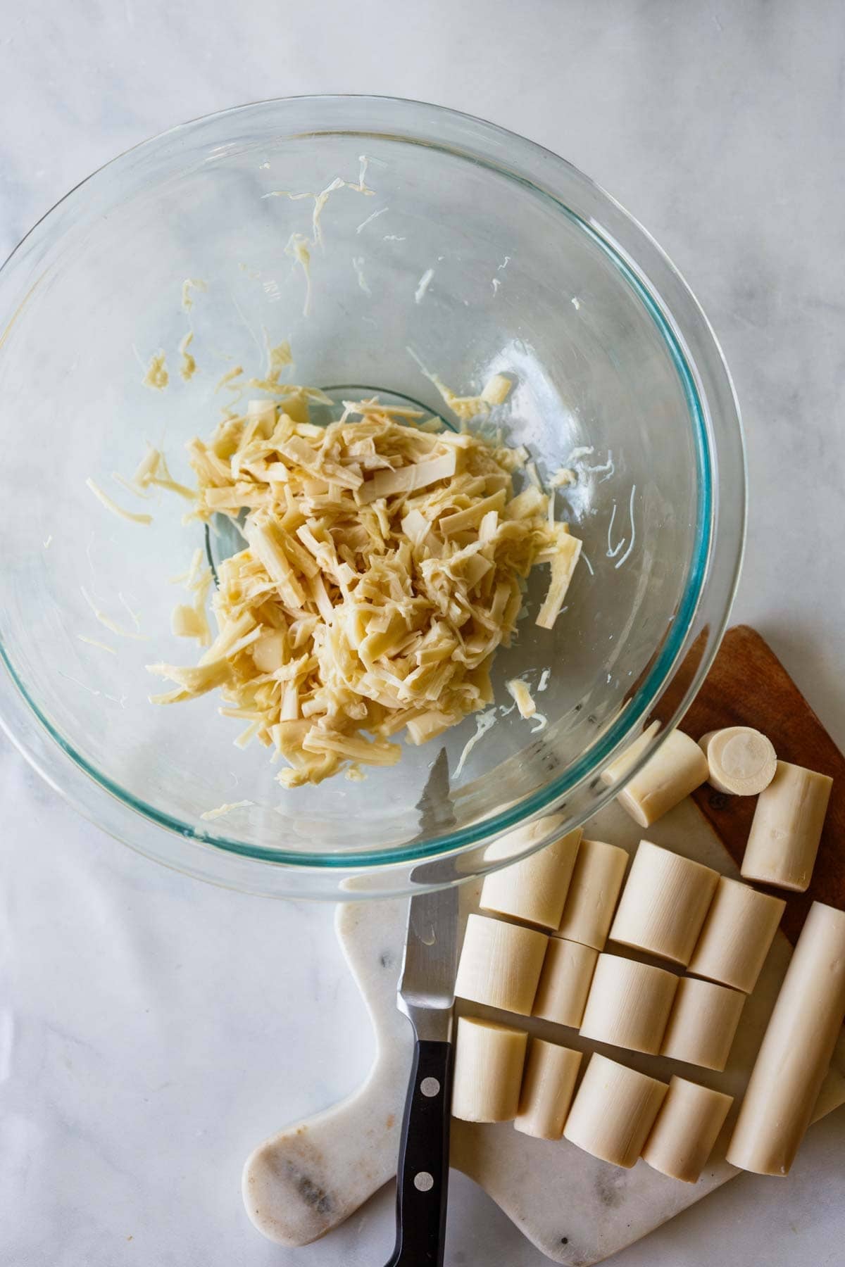 glass mixing bowl with shredded hearts of palm. 