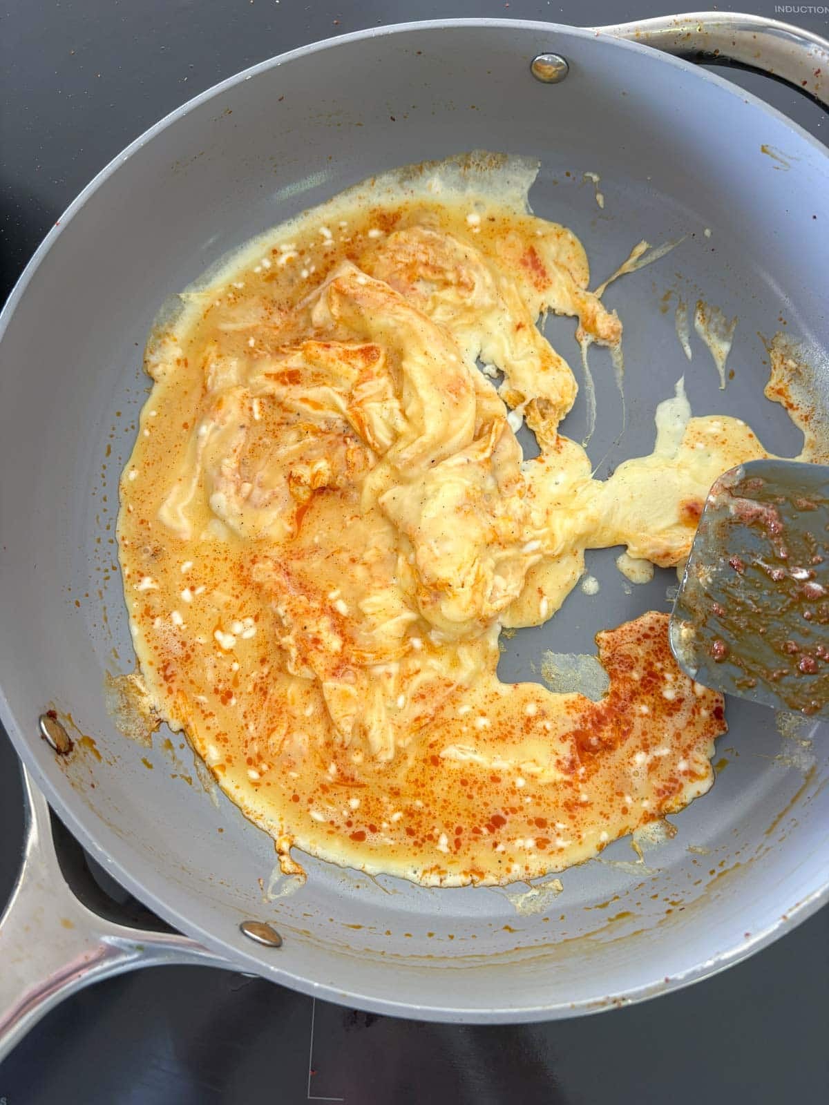 scrambling eggs in a skillet to make breakfast tacos.