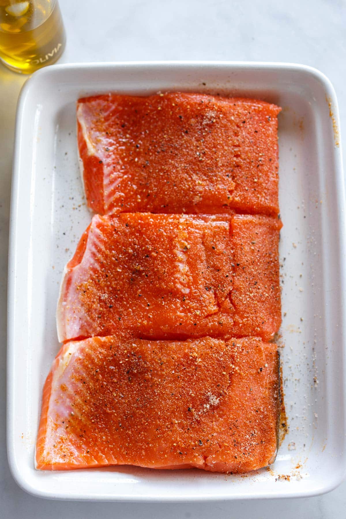 ceramic tray with salmon filets with dry rub.