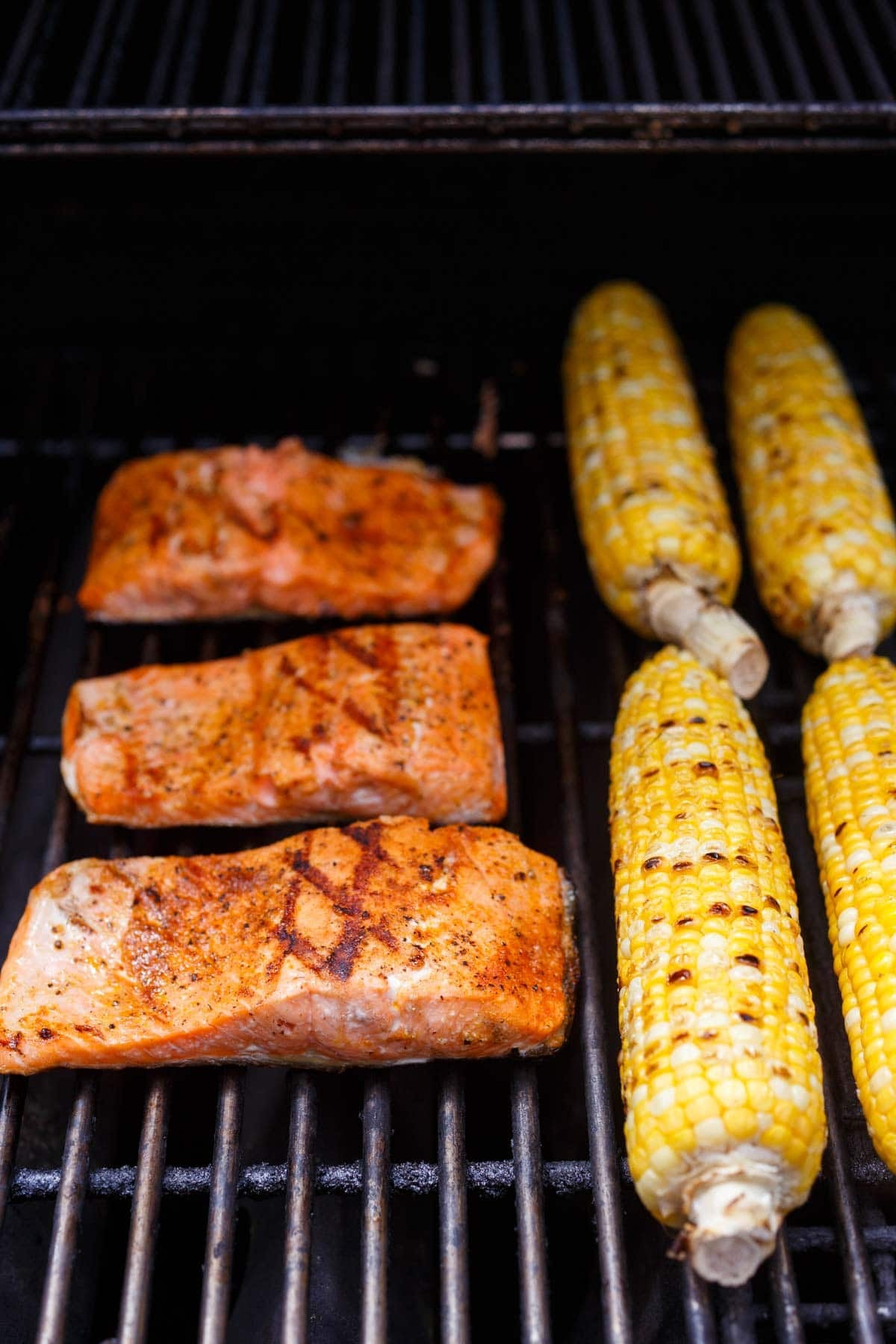 salmon filets and ears of corn on the grill.