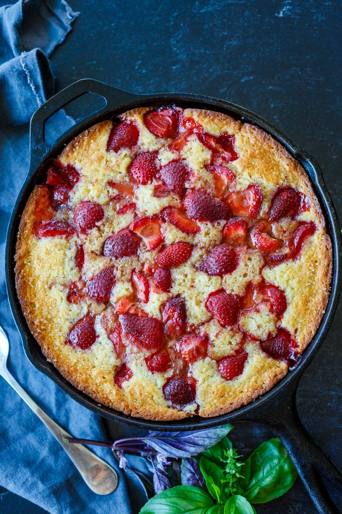baked strawberry cobbler in a cast iron skillet.