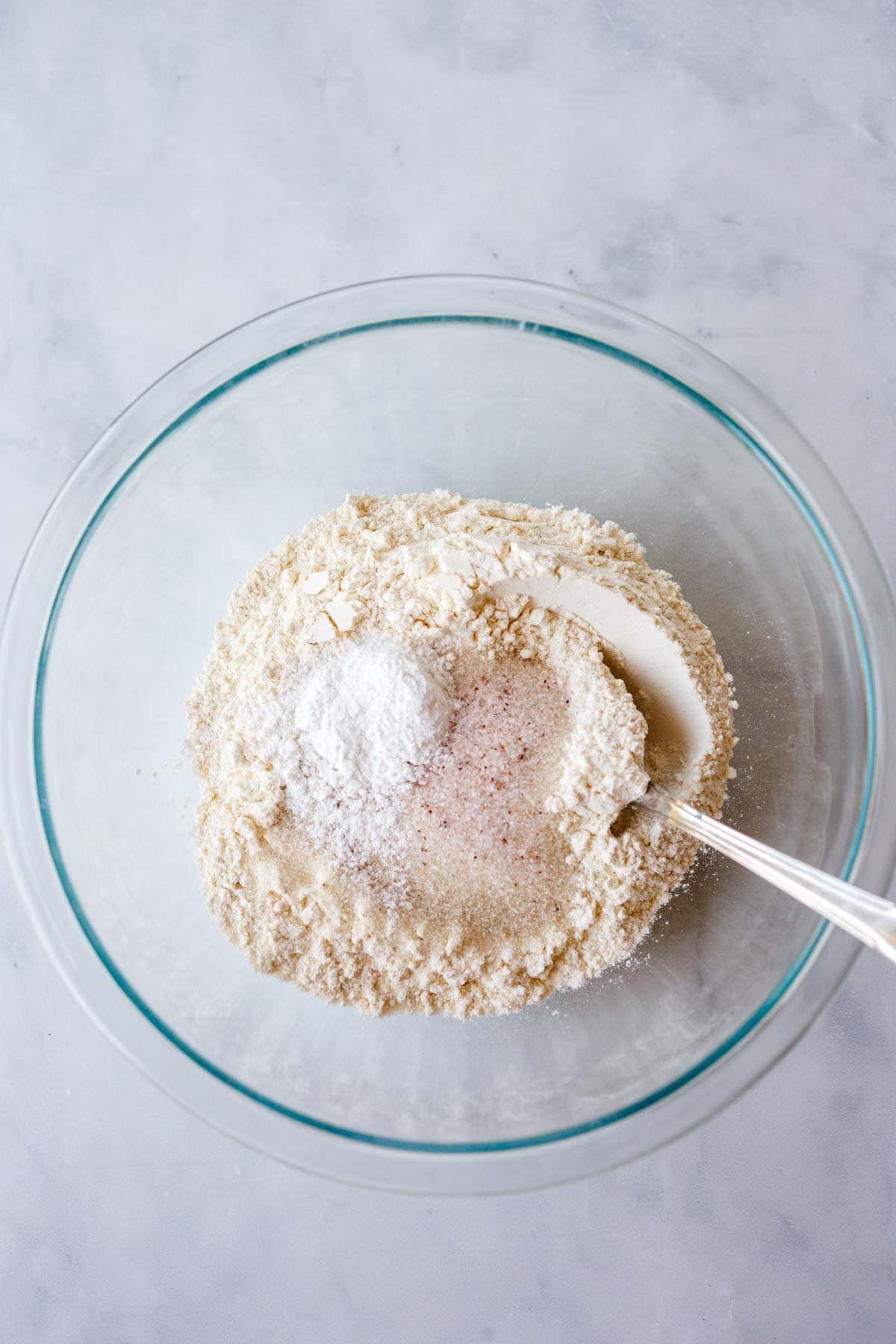 dry ingredients for strawberry cobbler in a glass mixing bowl.