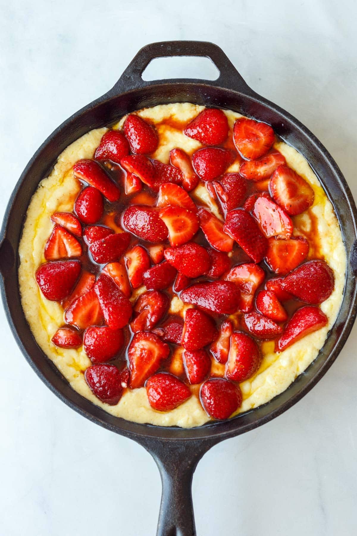 assembled strawberry cobbler in a cast iron skillet before baking.