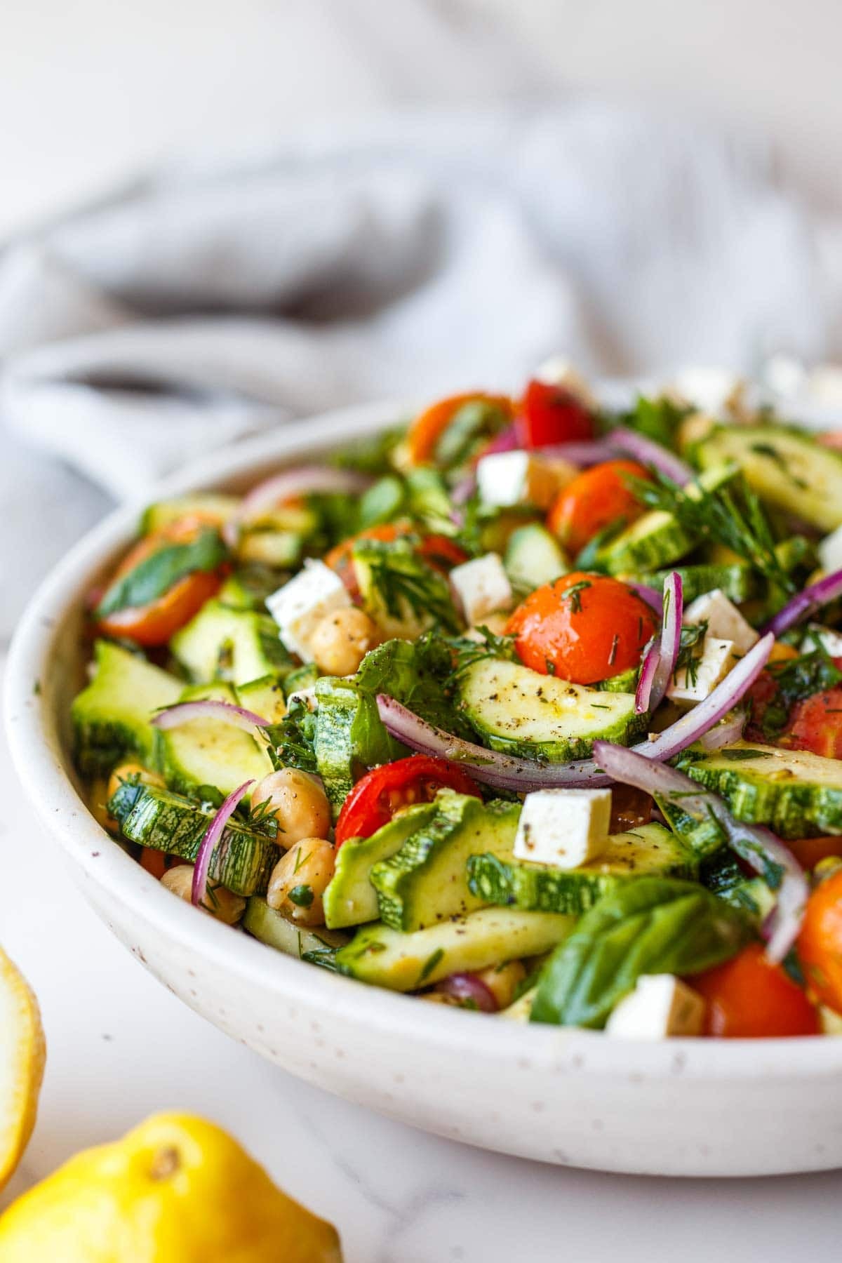 zucchini salad with tomato, onion, feta, chickpeas, and herbs.