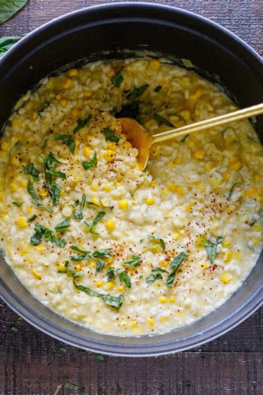 Corn risotto in a dutch oven with basil