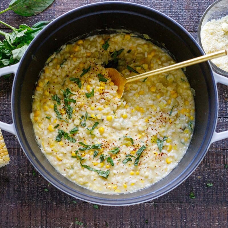 Corn risotto in a dutch oven with basil