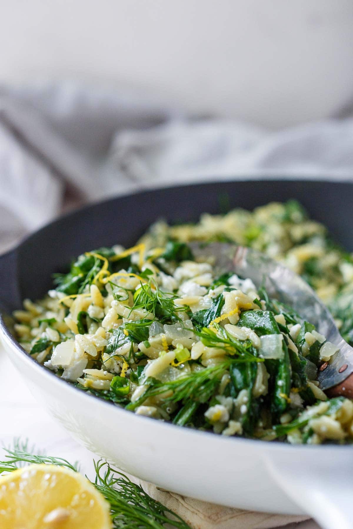 Close up view of Spanakopita Orzo with onions, lemon zest, creamy feta, dill, and spinach.