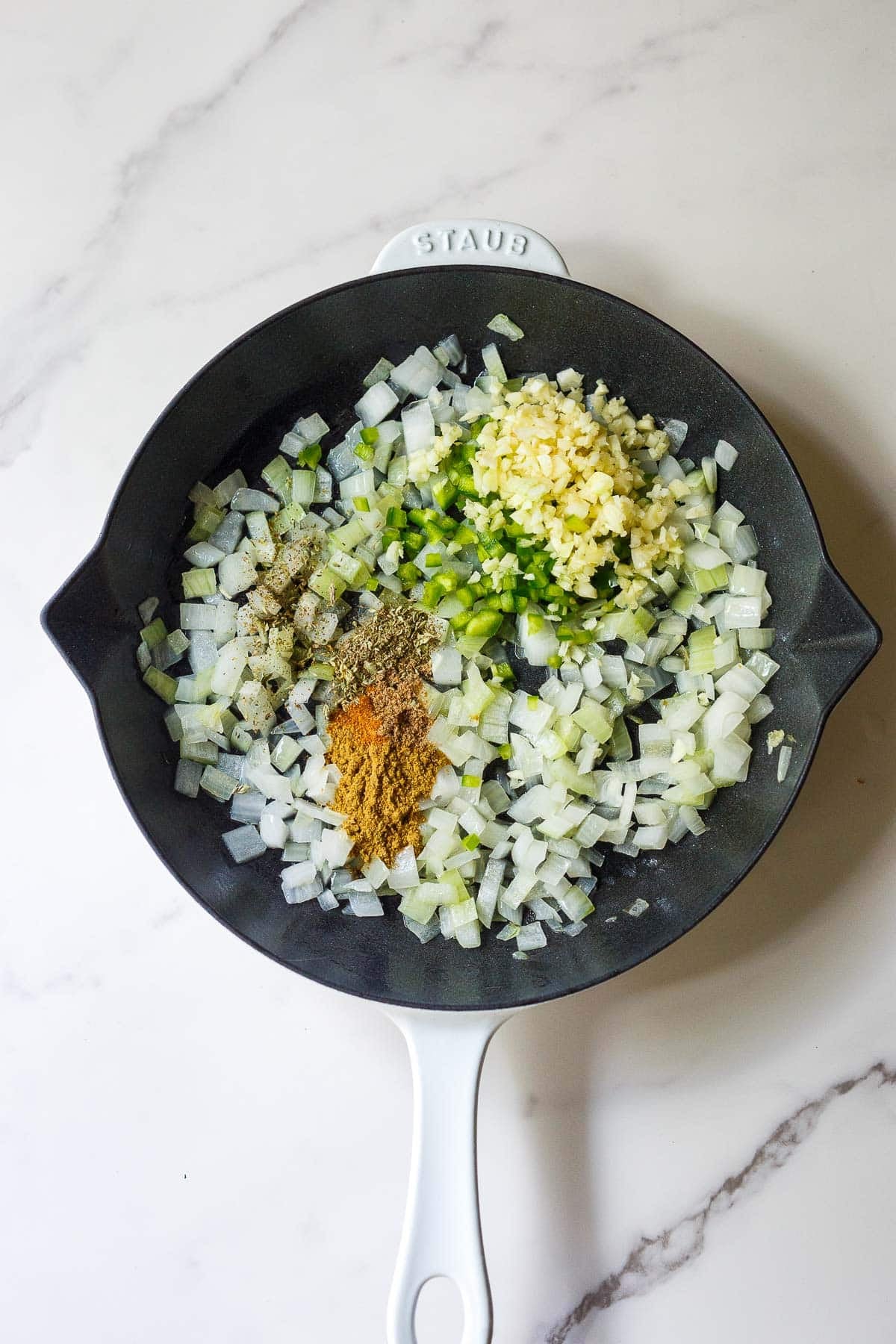 skillet with diced onion, poblano, jalapeno, zucchini, and spices.