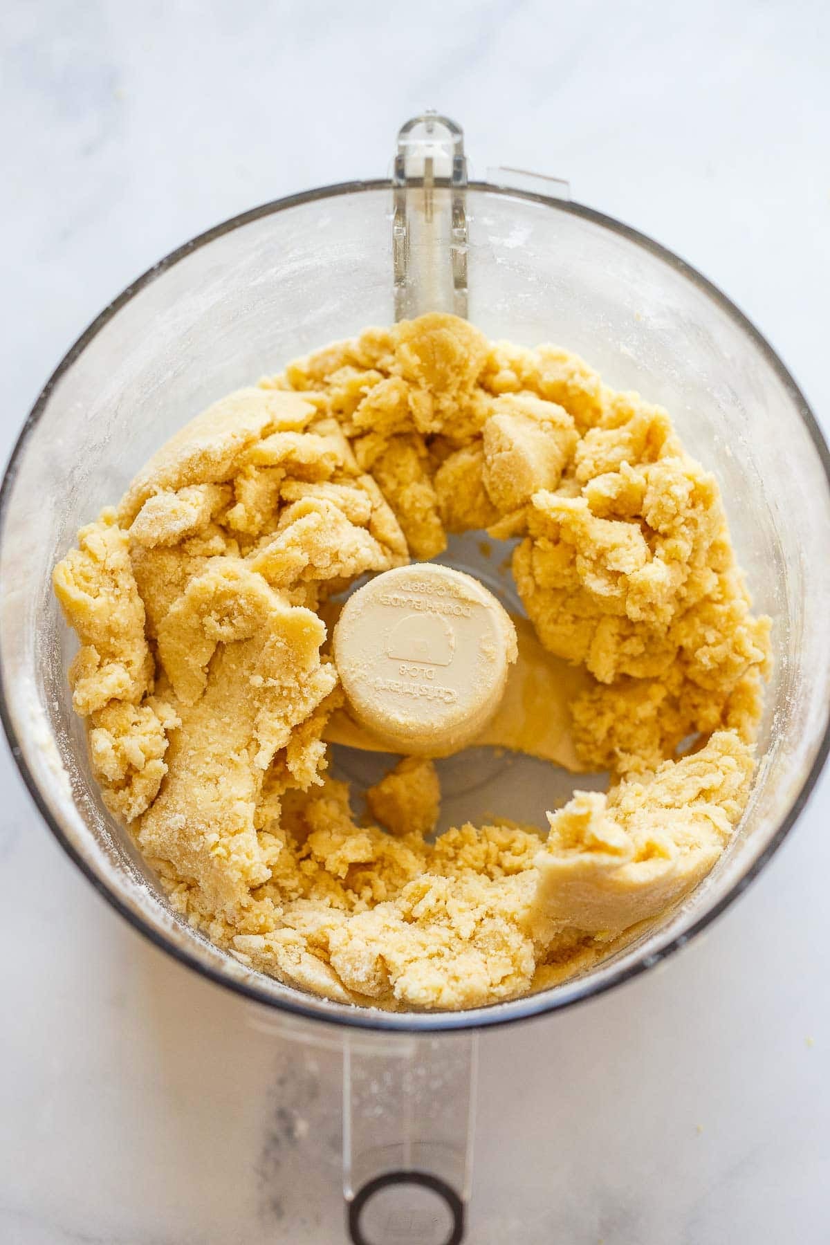 shortbread dough in a food processor just coming together to make lemon bars.