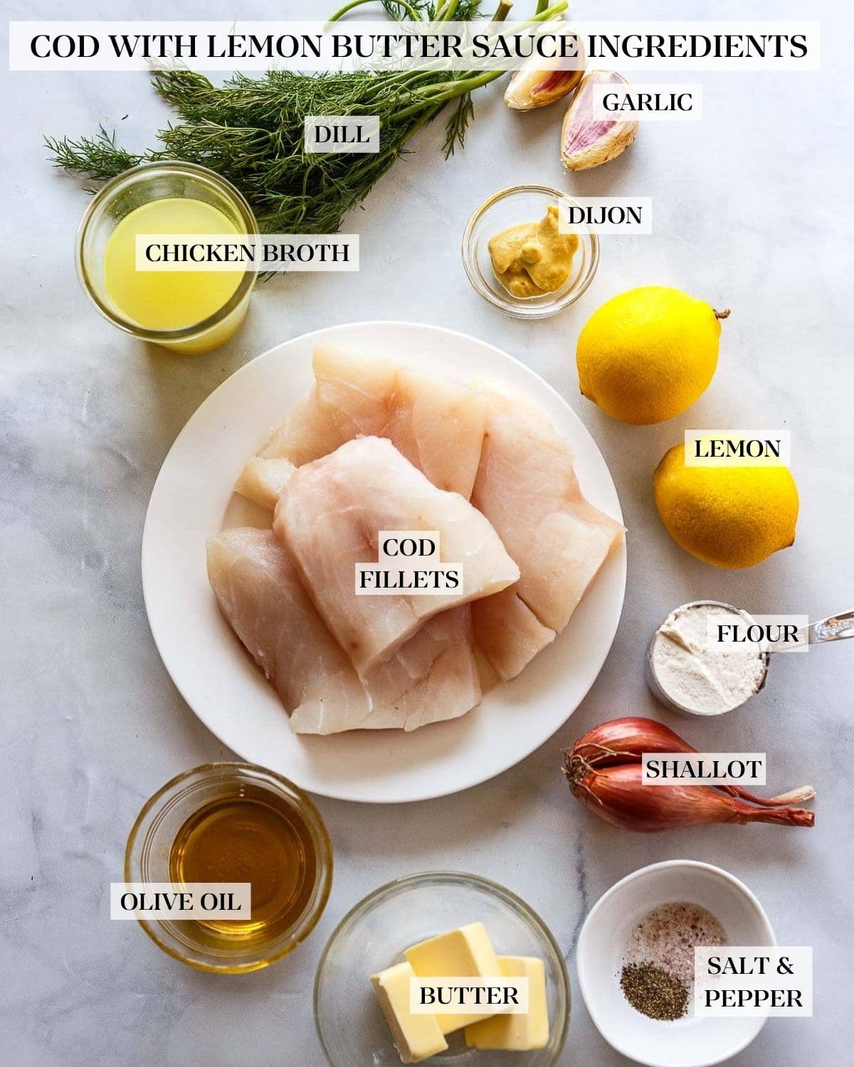 Lemon Butter Cod ingredients neatly arranged - bunch of dill, garlic cloves, pinch bowl with Dijon, glass of chicken broth, two lemons, plate of fresh cod, measuring cup with flour, shallot, pinch bowl with salt and black pepper, small dish of butter, small bowl of oil.