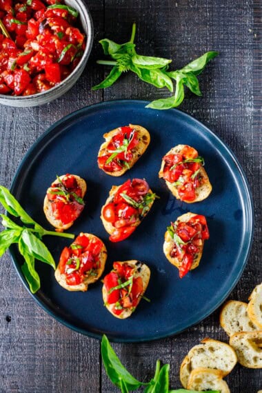 This easy Tomato Bruschetta is the perfect summer appetizer! Juicy ripe tomatoes, fresh basil, and olive oil are spooned over crisp toasted baguette rubbed with fresh garlic for incredible flavor. Simple, fresh, and perfect for entertaining.
