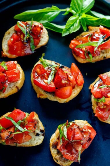 This classic Tomato Bruschetta is summer at its best—juicy ripe tomatoes, fresh basil, and crisp toasted bread rubbed with garlic for incredible flavor.
