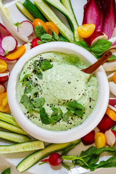 whipped cottage cheese dip with basil in a bowl with fresh veggies