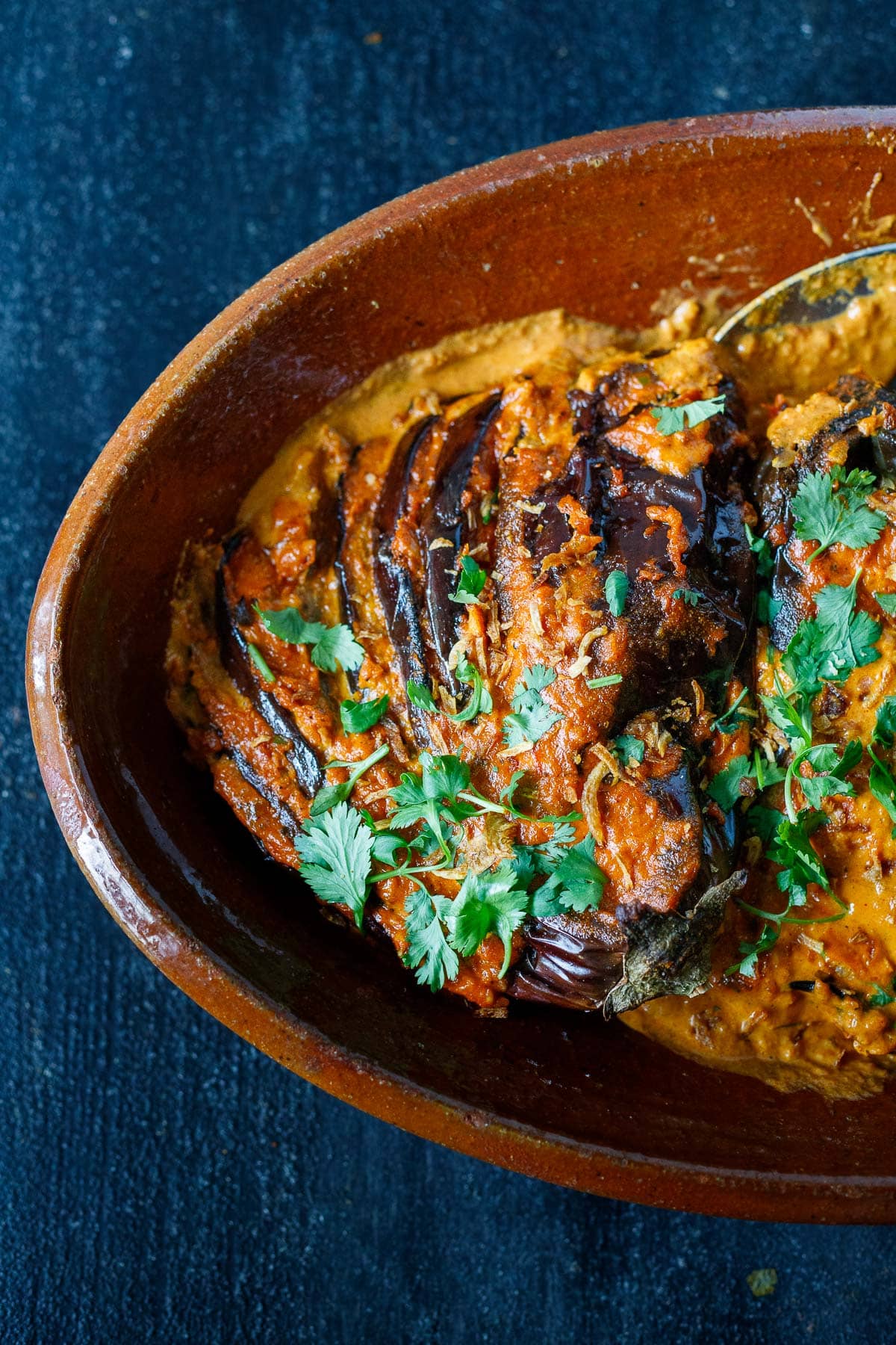 baked eggplant tikka masala with fresh cilantro and crispy shallots in a serving dish.