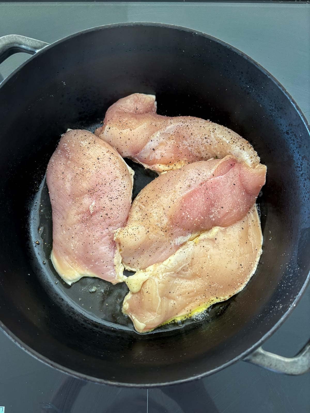 pot with seasoned chicken breasts.