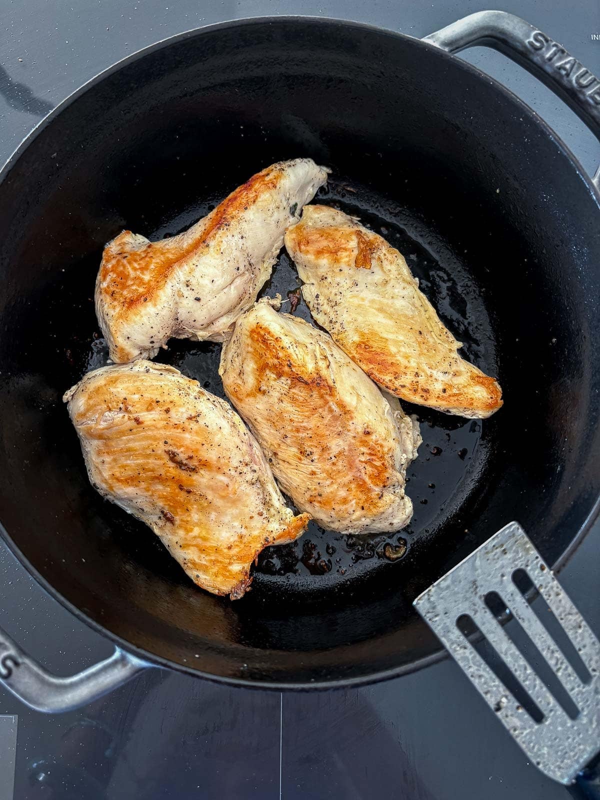 seared chicken breasts in a pot.