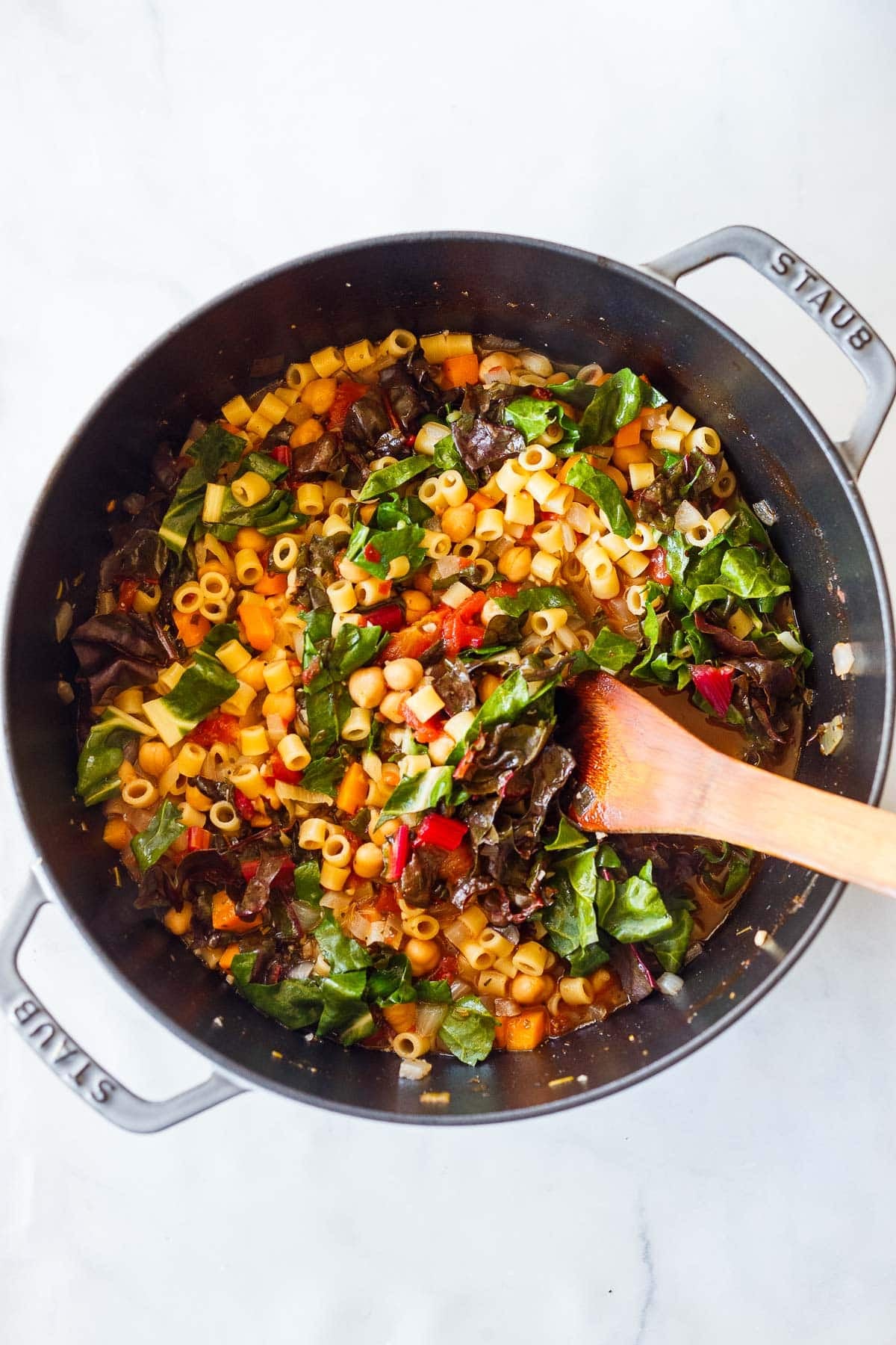 wilting the greens into the pot of pasta e ceci. 