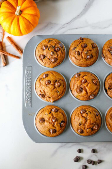 pumpkin chocolate chip muffins in a muffin tin.